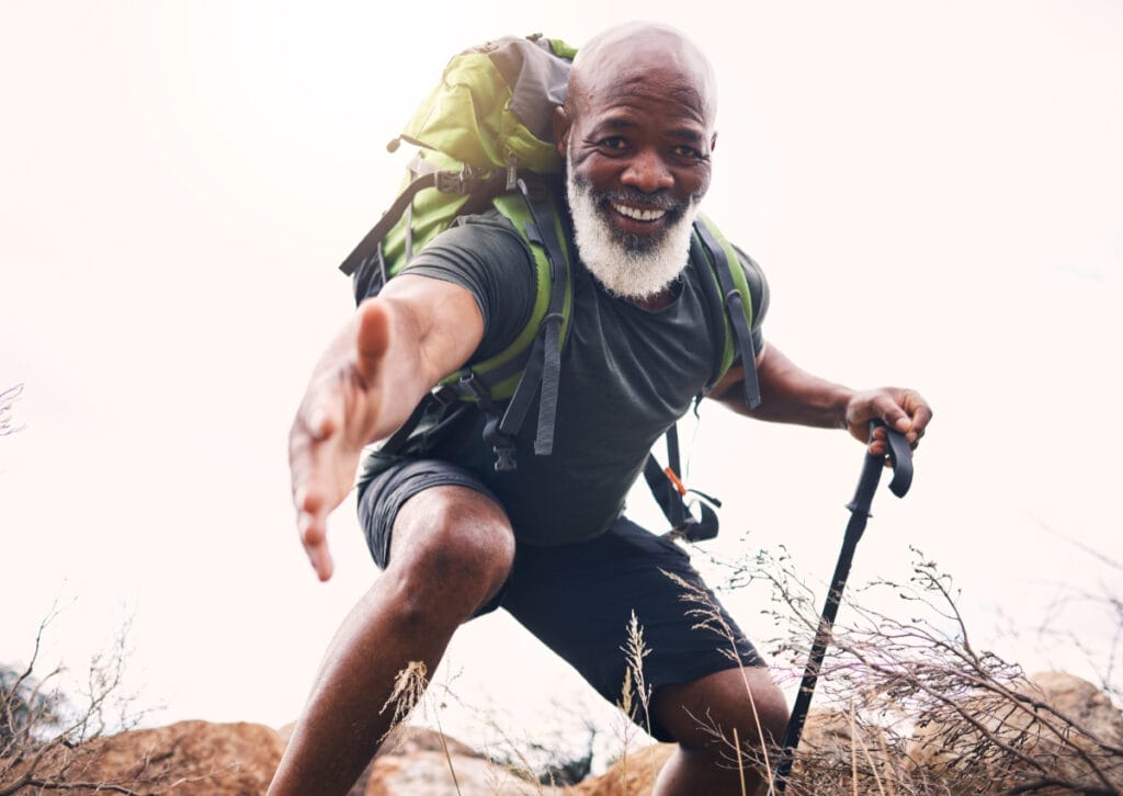 Senior man reaching to help hiker